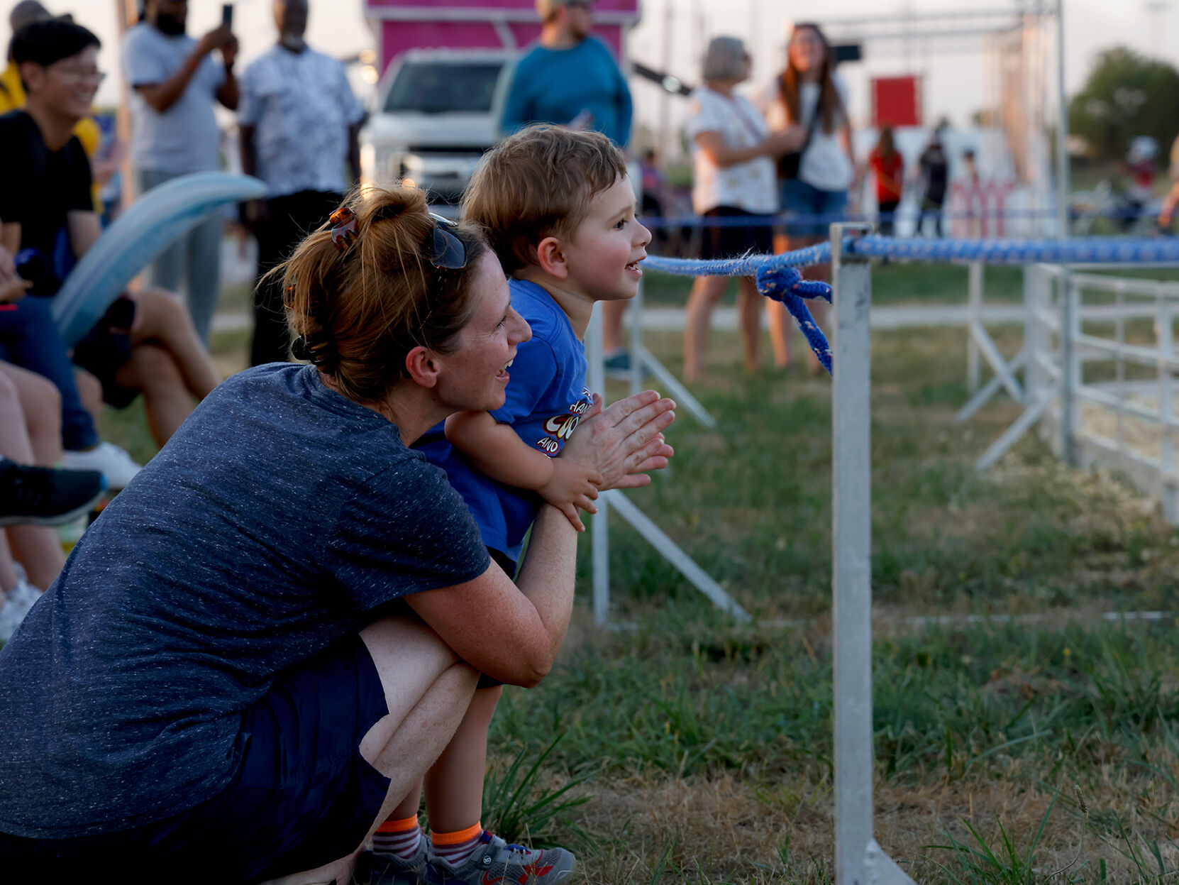 Kate Robbins and her son Jacob Robbins watch a swine race